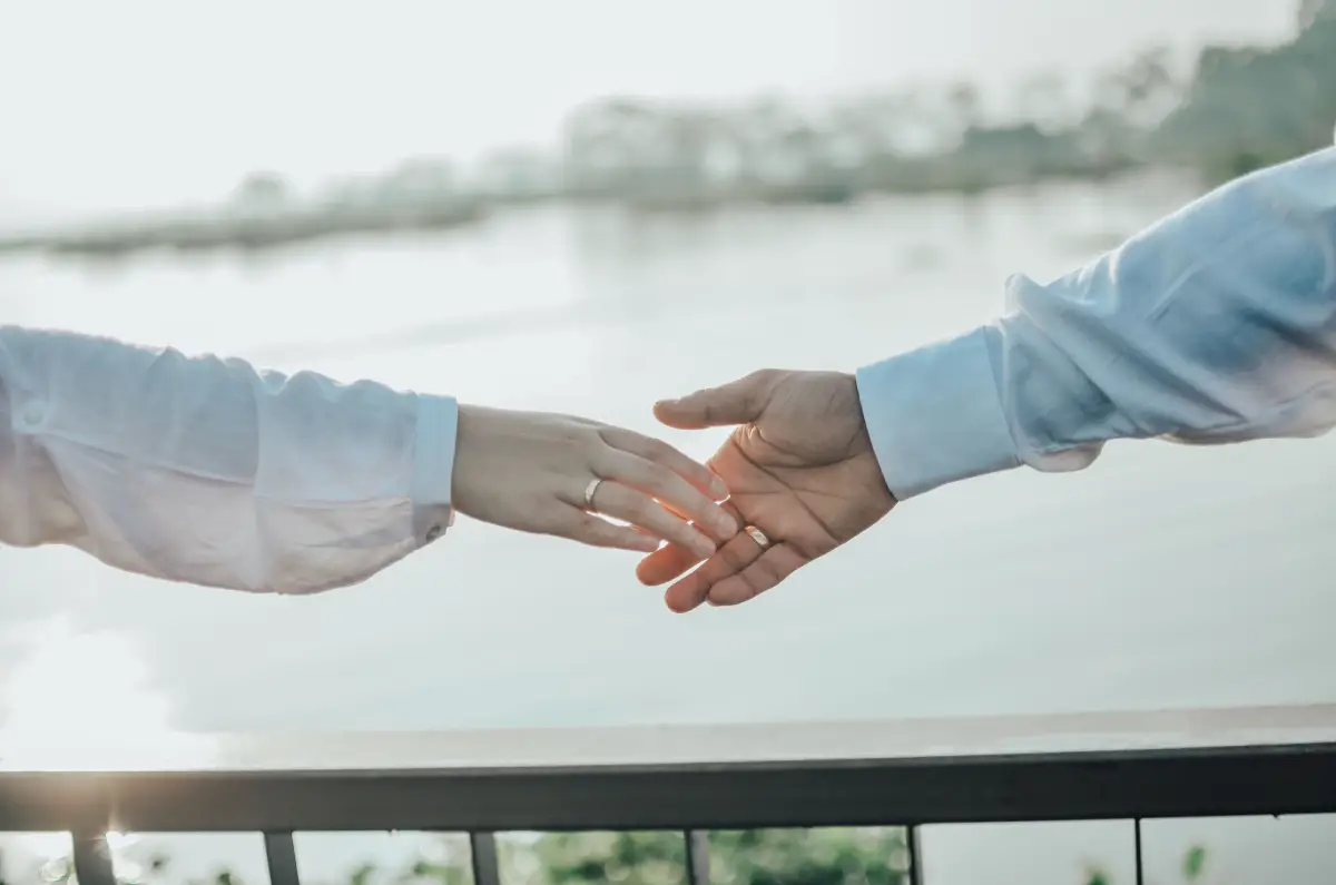 couple holding hands over bridge